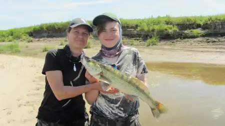 2 Angler Mutter und Sohn freuen sich über einen gefangenen Zander an der Elbe bei einem Angelguiding