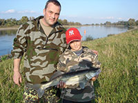 Vater mit Sohn bei einer gefürten Angeltour beim Zanderangeln an der Elbe mit einem Zander auf Gummifisch gefangen