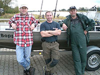 3 Angler vor einem Angelboot an der Elbe bei einer Zander Guiding Tour