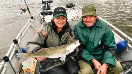 Angler Ehepaar freut sich über den Fang eines Zanders auf der Elbe